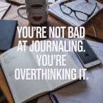 Open journal on a messy kitchen table surrounded by coffee cup, glasses, and everyday life items.