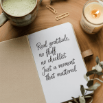 Soft, calming flat lay of an open linen journal next to matcha latte, candle, and eucalyptus sprigs. Page contains the handwritten quote “Real gratitude, no fluff. No checklist. Just a moment that mattered.” Earth-toned, minimalist vibe.